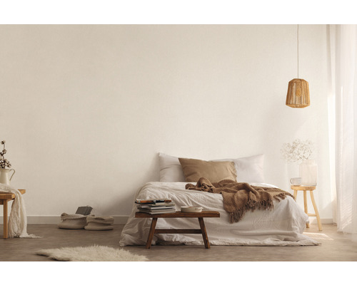 Lichte slaapkamer met bed, houten tafel, lamp en decoratieve elementen