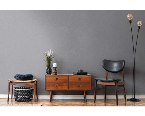 Woonkamer met houten commode, stoel, kruk en staande lamp