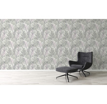 Woonkamer met bladerbehang en fauteuil met voetenbank