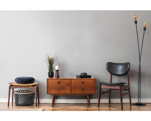 Woonkamer met ladekast, stoel, kruk en vloerlamp