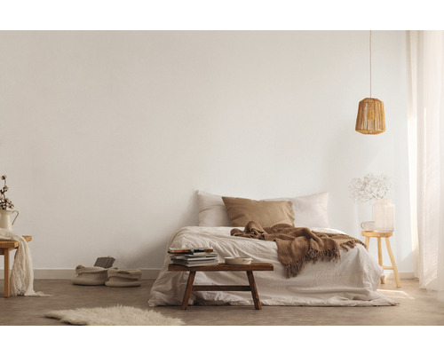 Lichte slaapkamer met bed, houten kruk en gebreide lamp