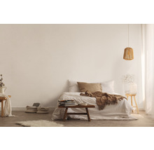 Lichte slaapkamer met bed, deken, kussens, lamp, tafel en decoraties voor een gezellige sfeer