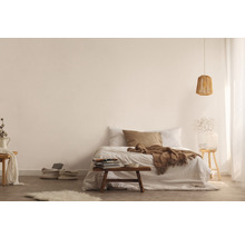Lichte slaapkamer met bed, houten kruk, lamp en decoratieve elementen voor een vriendelijke sfeer
