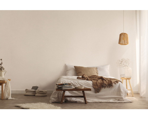 Lichte slaapkamer met bed, houten kruk, lamp en decoratieve elementen voor een vriendelijke sfeer