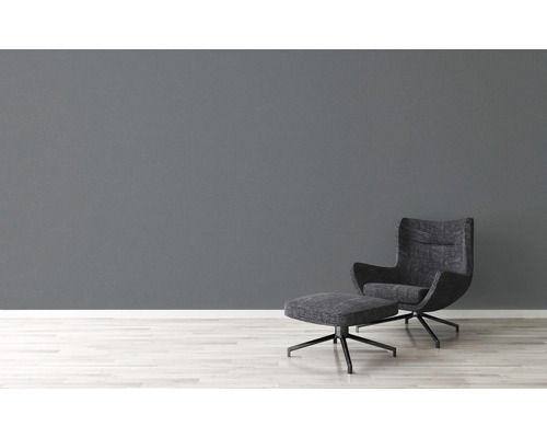 Moderne woonkamer met fauteuil en voetenbank op een lichte houten vloer