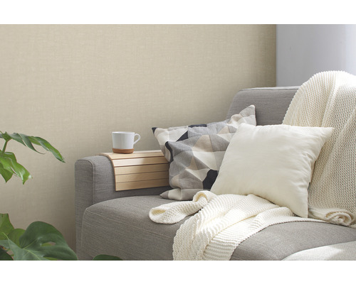 Woonkamer met grijze bank, kussens en beige behang