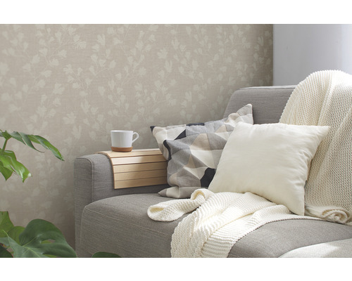 Woonkamer met bloemenbehang, bank, kussens en drankhouder