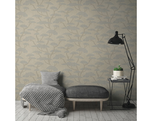 Woonkamer met behang met boommotief, stoel, kruk en staande lamp
