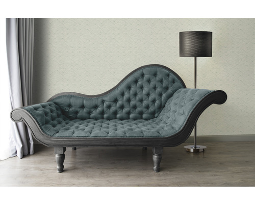 Chaise longue met knoophechting en staande lamp in een woonkamer