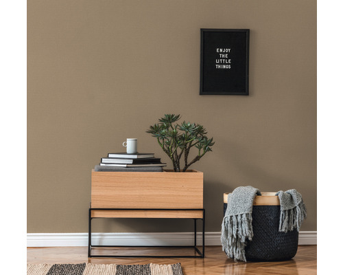 Decoratief interieur met houten tafel, plant, boeken, beker en mand met deken