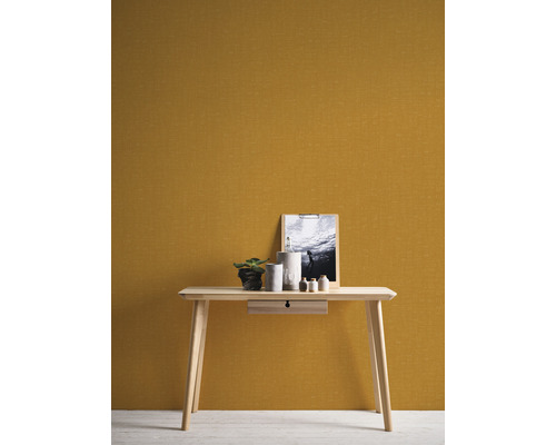 Houten tafel met lade, decoratie en foto tegen een muur