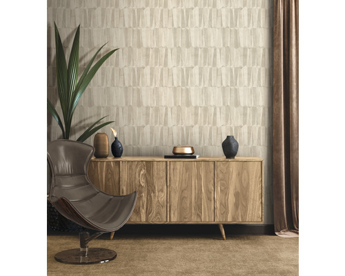 Woonkamer met modern design: behang, houten dressoir, fauteuil en kamerplant.