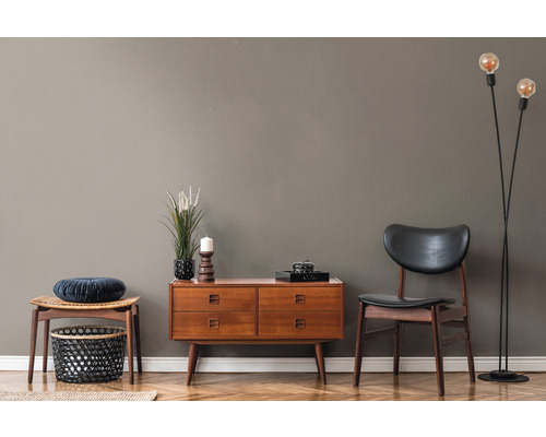 Woonkamer met houten commode, stoel, kruk en staande lamp