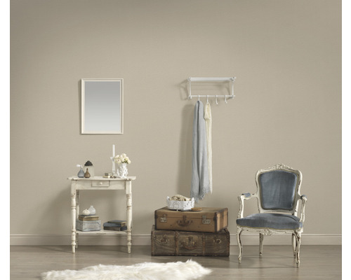 Decoratieve woonkamer met tafel, spiegel, bagage, stoel en kapstok.