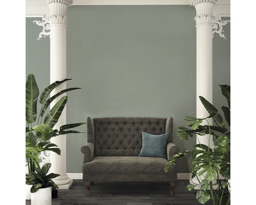 Interieurbeeld met bank, kussen, zuilen en planten.