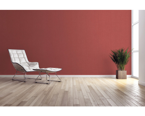 Woonkamer met fauteuil, voetenbank, kamerplant en wanddecoratie