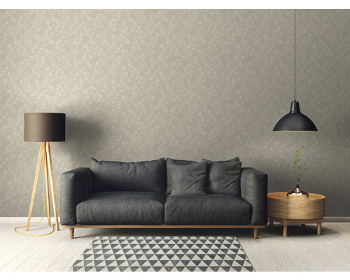 Woonkamer met bank, staande lamp, hanglamp en behang met motief