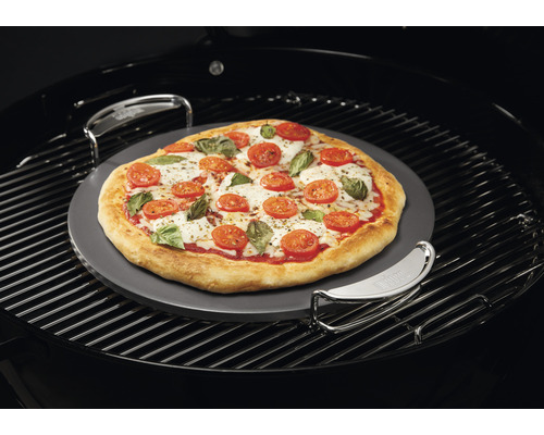 Pizza op pizzasteen in de barbecue