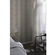 Slaapkamer met patroonbehang, bed, lamp en stoel