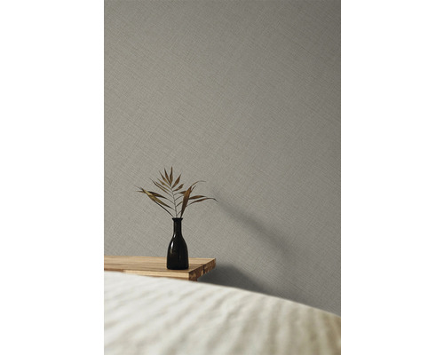 Close-up van een grijs vliesbehang met een fijn textielpatroon