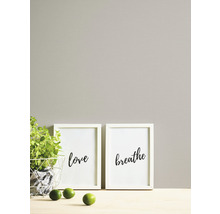 Decoratieve fotolijsten met de woorden liefde en ademen naast een plant en limoenen
