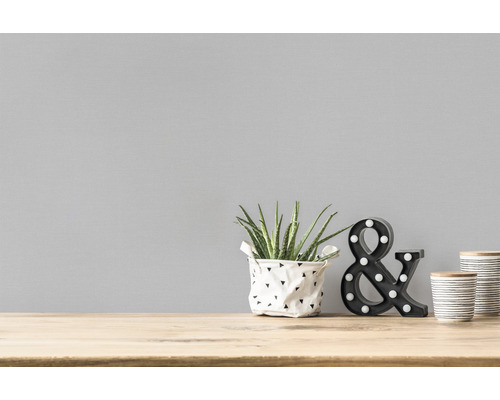Decoratief stilleven met kamerplant, decoratieve ampersand en containers op een houten tafel