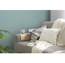 Decoratieve woonkamer met bank, kussens, plaid, houten plank en beker
