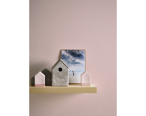 Decoratieve huisjes van beton en een klembord met een foto op een houten plank.