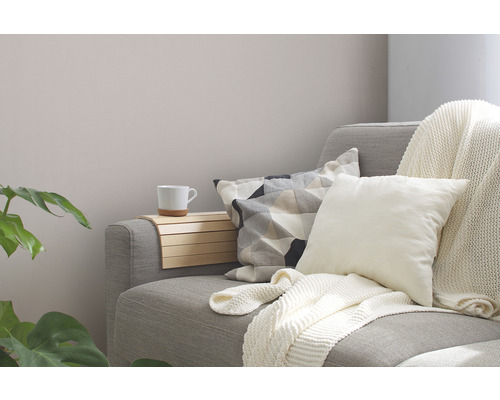 Gezellige woonkamer scène met bank, kussens, deken en bijzettafel