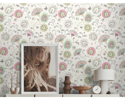 Woonkamer met bloemenbehang, ladekast, tafellamp, klok en decoratie