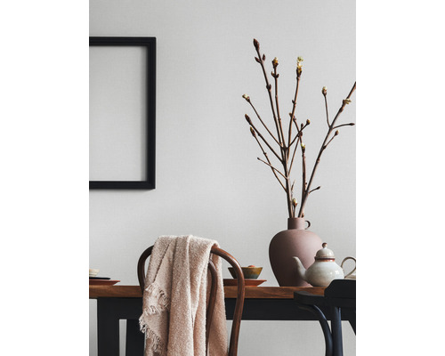 Lichte eetkamer met houten tafel, stoelen, decoratie en lijst