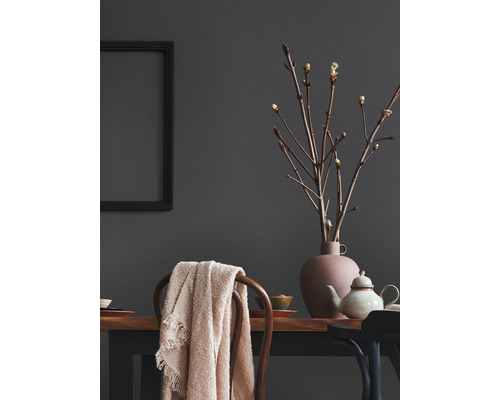 Decoratief interieur met tafel, stoel, vaas, takken en textiel.