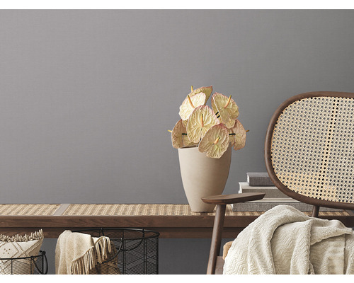 Decoratief stilleven met anthuriums in vaas en rotan stoel