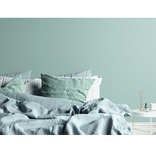 Slaapkamer met bed, kussens en nachtkastje