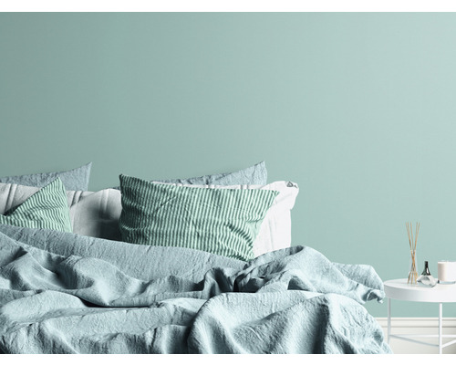 Slaapkamer met bed, kussens en nachtkastje