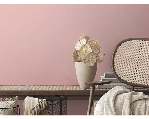 Licht interieur met bloemen in vaas en rotan stoel voor een roze muur