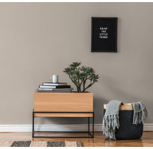 Decoratief interieur met houten plantenbak, mand, boeken en wandbord.