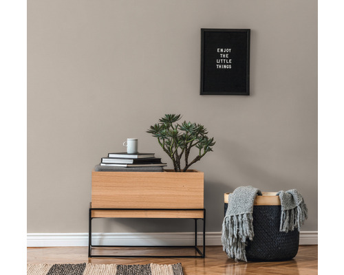 Decoratief interieur met houten plantenbak, mand, boeken en wandbord.