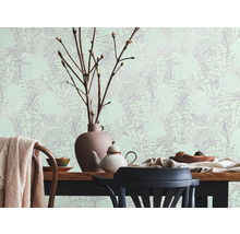 Lichte kamer met eettafel, servies en behang met bladerpatroon