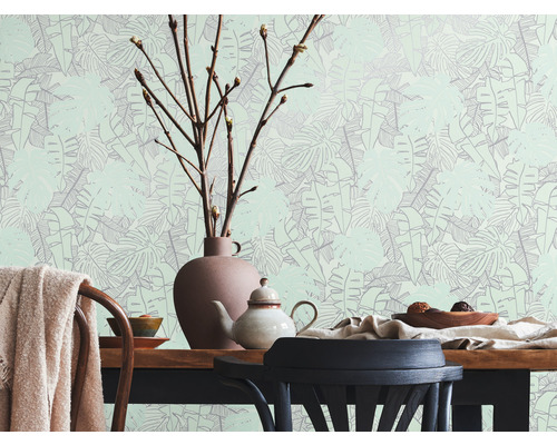 Lichte kamer met eettafel, servies en behang met bladerpatroon