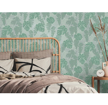 Slaapkamer met bed en tropisch bladerenbehang