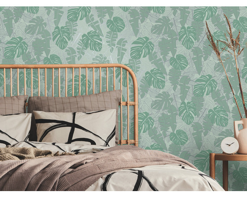 Slaapkamer met bed en tropisch bladerenbehang