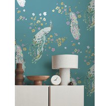 Wand met pauwenbehangpatroon, versierd met lamp, schaal, klok en vaas op een dressoir.