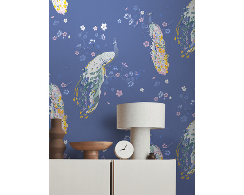 Decoratief interieur met behang met pauwenmotief, tafellamp en woonaccessoires op een dressoir