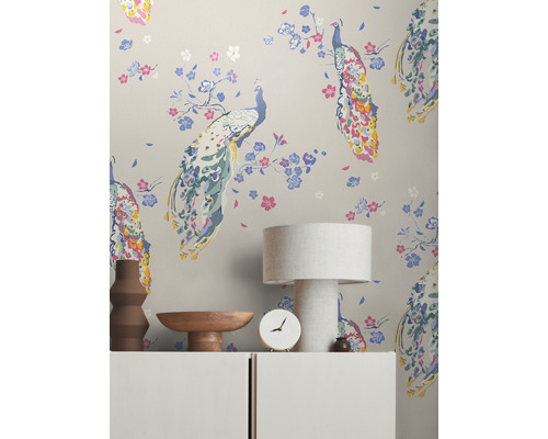 Scene met behang met pauwenmotief, tafellamp, klok en decoratie op een kast.