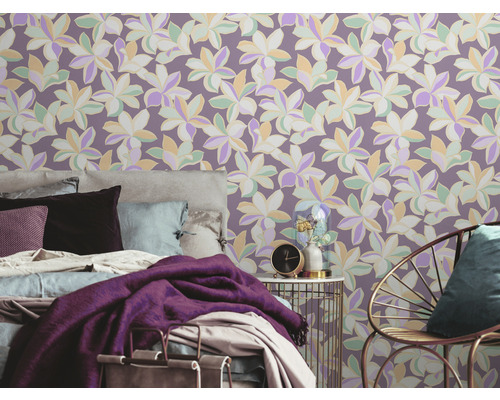 Slaapkamer met bloemenbehang, bed, stoel en bijzettafel.