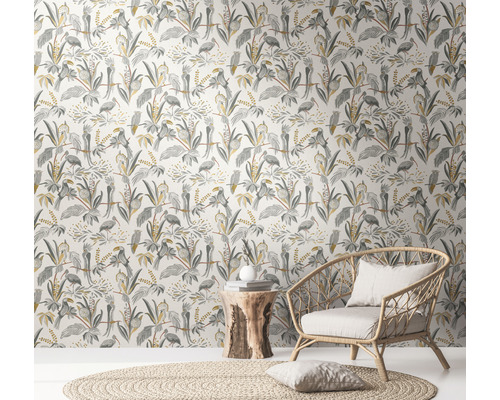 Kamer met junglebehang met vogels en planten, rotan stoel en houten bijzettafel