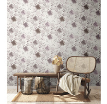 Gezellige woonkamer met bloemenbehang, houten bank, rotan stoel, tapijt en decoraties.