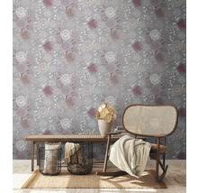 Decoratief interieur met een bloemrijk behang, een houten bankje en een schommelstoel.