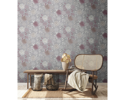 Decoratief interieur met een bloemrijk behang, een houten bankje en een schommelstoel.